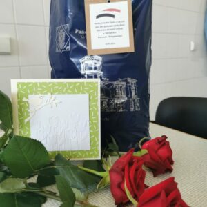 Na zdjęciu kwiaty, kartka z życzeniami i prezent dla pielęgniarek