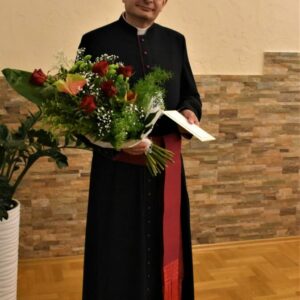 Ksiądz prałat dr Wojciech Pac z bukietem kwiatów