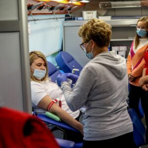 Ochotniczka oddaje krew pod okiem pielęgniarki