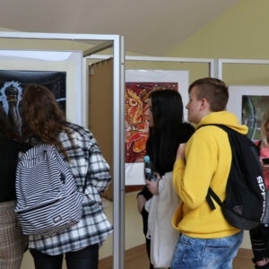Młodzież ogląda prace studentów w galerii 